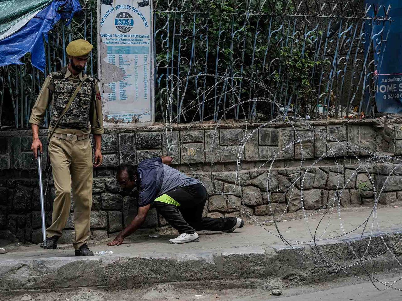 A Kashmiri man cross barbed wire set up by police as a roadblock during a restrictions in Srinagar, Indian controlled Kashmir, Sunday, Aug. 7, 2022. This project documents ongoing unrest in the long-disputed region of Kashmir, dating back to 1947, when India and Pakistan gained independence from Britain. Both nations claim Kashmir in its entirety, and each administers a portion of the region. In Indian-administered Kashmir, rebels have been fighting Indian rule for decades, seeking to unite the territory, either under Pakistani rule or as an independent country. India says that Pakistan supports armed insurgency in Kashmir. Pakistan denies the charge, saying it provides moral and diplomatic support only.